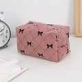 Detailed close-up of pink corduroy makeup bag with black bow patterns and silver zipper - Dark Pink Bow