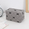 Detailed close-up of grey corduroy makeup bag featuring black bow patterns and silver zipper - Gray Bow