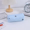 Macro-opname van blauw gewatteerd etui met zwarte strikborduring op bureau - Blauw
