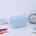 Detailed macro view of soft light blue plush pencil case with metallic zipper closure - Blue