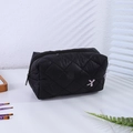 Détail d'une trousse de maquillage matelassée noire avec nœud rose à paillettes et zip - Trousse à Maquillage Noire