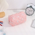Pochette matelassée rose à nœuds bleus sur un bureau avec des fournitures - Nœud (fermeture Éclair Rose)