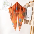 Orange pleated scarf with ginkgo leaf print hanging on a wooden hanger in cozy setting - 80*80cm / Orange