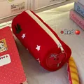 Rode canvas pennenzak met sterpatronen en appelborduurwerk op een bureau - Rode Appel