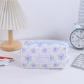 Close-up of quilted floral pencil case with sweet girl tag and blue zipper detail - Blue