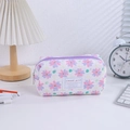 Detail of floral quilted pencil case with sweet girl label and purple zipper on desk - Purple