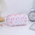 Floral quilted pencil case with sweet girl label and pink zipper on a cozy desk - Pink