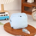 Gros plan d'une trousse de maquillage matelassée bleu clair avec coutures en losange - Bleu
