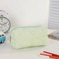 Close-up of light green quilted pencil case with blue zipper and puffy texture detail - Solid Mint Green