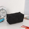 Macro shot of the black quilted pencil case fabric and silver metal zipper detail - Solid Black Sea