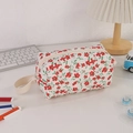 Detailaufnahme der gesteppten Federtasche mit Blumenmuster und Reißverschluss - Handgehalten rotes Blumenmuster