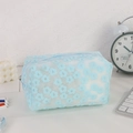 Dettaglio della pochette in rete azzurra con ricami floreali bianchi e cerniera argentata - Celeste
