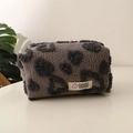 Detail of plush grey teddy fleece makeup bag with dark grey heart patterns and label - Coffee