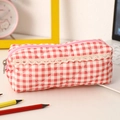Detail of pink plaid pencil case featuring quilted fabric and elegant lace trim detail - Red