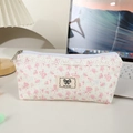 Roze etui met bloemenprint, kanten rand en Rise and Shine label op een bureau geplaatst - Volledige Bloemen Kant Stijl