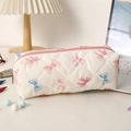 Gros plan sur la trousse matelassée avec motifs de nœuds roses et fermeture éclair rose - Bleu Rose Ruban