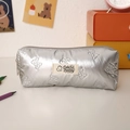 Detail eines silbernen gesteppten Federmäppchens mit Schmetterlingsmuster auf dem Tisch - Silber