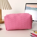 Pink quilted makeup bag with metal zipper on a desk with a lamp and notebook - Rose Red