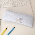 Detail of light blue pencil case featuring quilted texture and colorful bow embroidery - Blue
