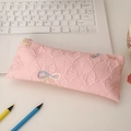 Detail of pink quilted pencil case with bow embroidery and metal zipper texture - Pink