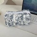 Détail d'une trousse à maquillage matelassée fleurie avec motifs botaniques et fermeture - Motif Floral Bleu Foncé