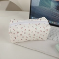 Detailansicht der gesteppten Kosmetiktasche mit Kirschmuster auf einem Laptop - Weiß mit Kirschen