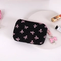 Detalle del monedero de tela plisada negra con lazos rosas y dije de perlas - Negro (con Lazo Rosa)