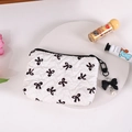 Detalle del bolso plisado blanco con lazos negros y colgante de lazo con perla - Blanco (Lazo Negro)