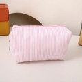 Detail of pink and white striped canvas pouch showing fabric texture and zipper closure - Pink
