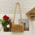 Macro shot of gold woven metal texture and chain strap on a designer shoulder bag - Rose Gold