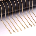 Detail van gouden slangenkettingen met karabijnsluiting op cilindrische displaystandaards - Ronde Slangenketting (2mm) / 45cm / Goud