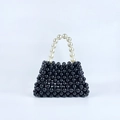 Detail of handmade black beaded handbag with large white faux pearl handle in retro style - Black