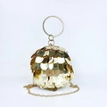 Macro detail of golden spherical evening clutch featuring reflective sequins and metal ring - Gold