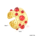 Dettaglio anello dorato largo con trama metallica martellata e pietre cabochon rosse - Stile Gemma Rossa Martellata Vintage (RI1675E7G)
