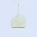 Dettaglio borsa tessuta a mano con perle, struttura a triangolo e chiusura elegante - Bianco latte