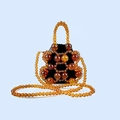 Macro detail of amber beaded bucket bag with tortoiseshell texture and black drawstring liner - Amber