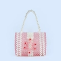 Dettaglio di perle acriliche rosa e perle bianche con motivo floreale rosso intrecciato - Rosa
