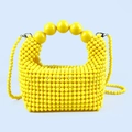 Macro detail of glossy yellow handmade beaded bag featuring polished pearl top handle - Yellow