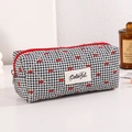 Detail of quilted cherry pattern pencil case with red zipper and black plaid fabric - Black
