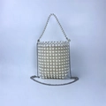 Detailed view of woven bead bag featuring clear pearls and silver metal chain strap - Clear