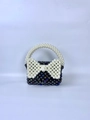 Macro detail of handmade beaded handbag with white pearl bow decoration and top handle - Black