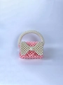 Close-up of pink beaded handbag with a white pearl bow and decorative handle - Pink