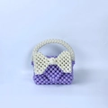 Detail van handgemaakte paarse kralentas met een grote witte parel strik accent - Violet
