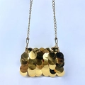 Detalle de un mini bolso de lentejuelas doradas con correa de cadena metálica - Dorado