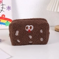 Nahaufnahme des flauschigen Keks-Mäppchens mit niedlichem besticktem Gesichtsausdruck - Dunkelkaffee