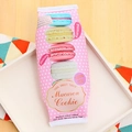 Astuccio rosa a pois con motivo macaron esposto su un piatto di ceramica bianca - Macarons