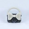 Detail of handmade beaded mini bag with metallic purple beads and white pearl bow accent - Black