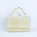 Close-up of handmade white pearl handbag with square woven texture and top handle - Milky White