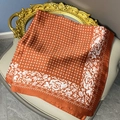 Detailed close-up of floral print silk scarf with white roses on orange fabric - 70cmx70cm / Amber