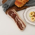 Détail d'une trousse en peluche créative motif bacon avec visage mignon sur un plateau repas - Poitrine de porc